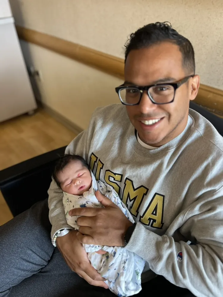 Robert Solano holding his newborn daughter Rio