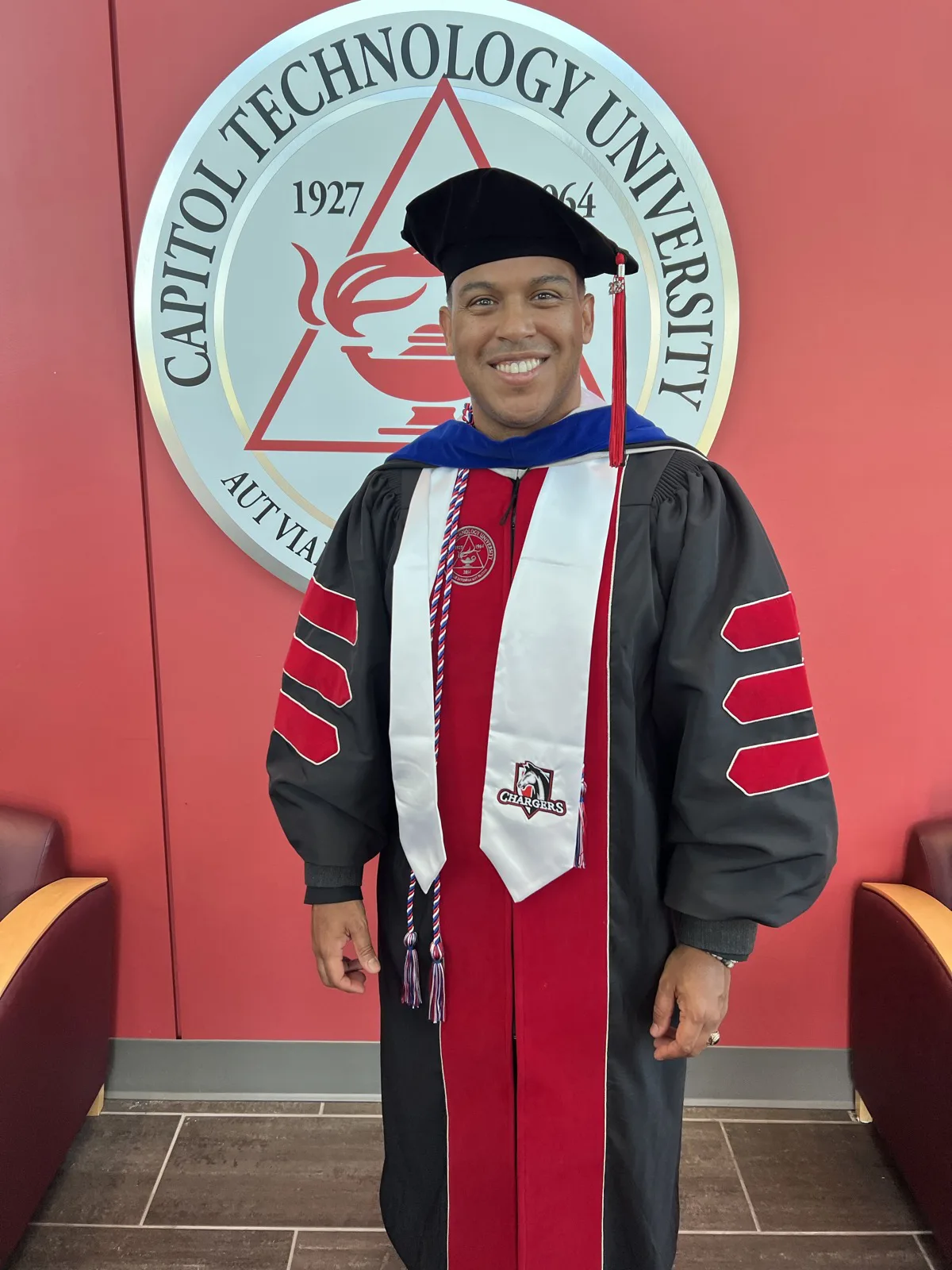 Robert Solano in doctoral regalia at Capitol Technology University after earning his PhD in 2025