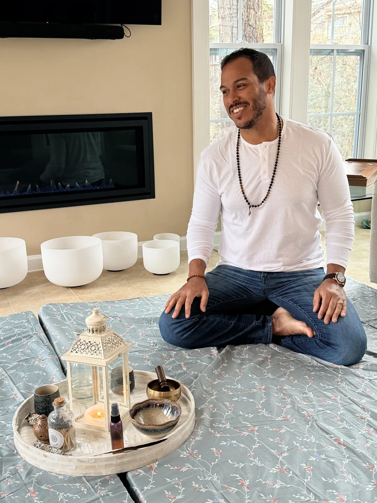 Robert Solano sitting cross-legged in circle beside crystal singing bowls and a small altar tray